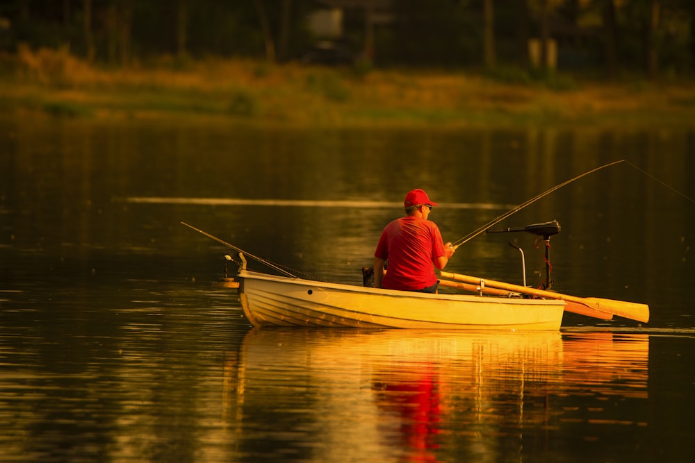 man in red cap and shirt fishing in lake