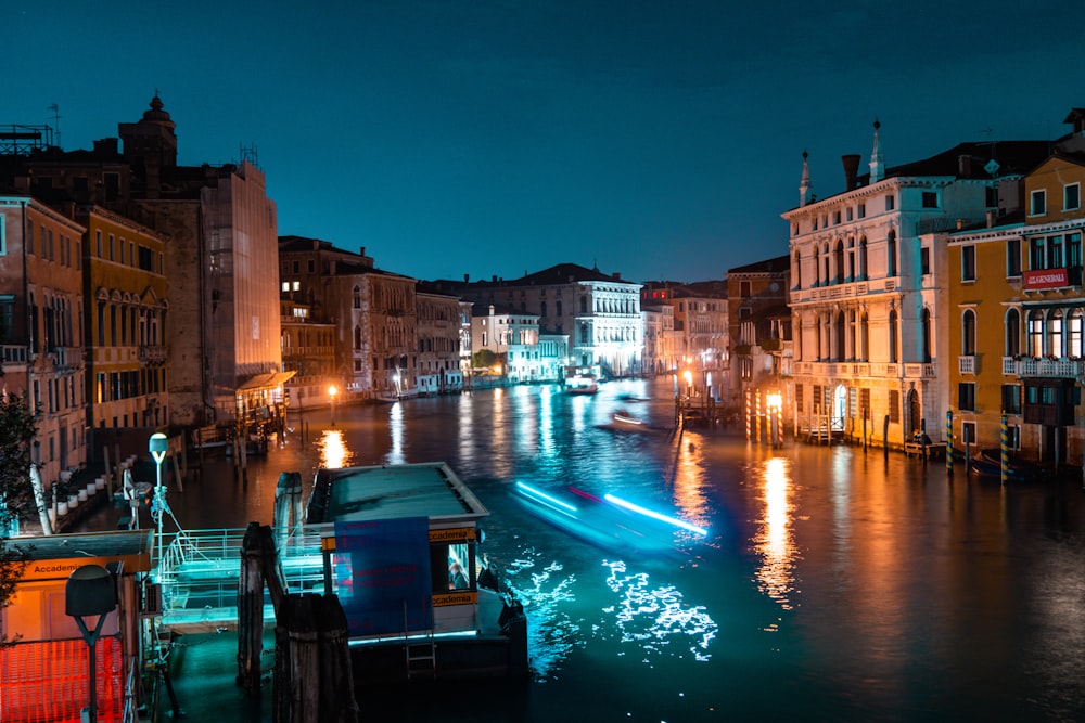 vessel floating in a canal in the city during nighttime