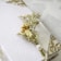 Close-up of a delicate dried flower rosary resting gently on a white lace cloth.
