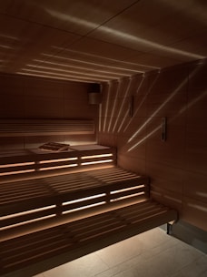 Warm wooden sauna interior with soft ambient lighting and comfortable seating.