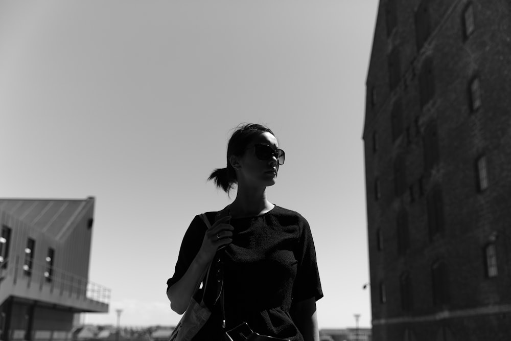 grayscale photography of woman walking in the street