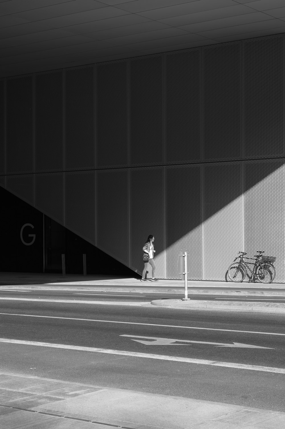 woman standing beside gray wall