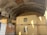 Several yellow shipping containers are stacked in a large concrete tunnel. The tunnel has a curved ceiling, and there's wood planking lining the upper sections. Sunlight partially illuminates the containers, revealing the logo 'MSC'.