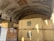Several yellow shipping containers are stacked in a large concrete tunnel. The tunnel has a curved ceiling, and there's wood planking lining the upper sections. Sunlight partially illuminates the containers, revealing the logo 'MSC'.