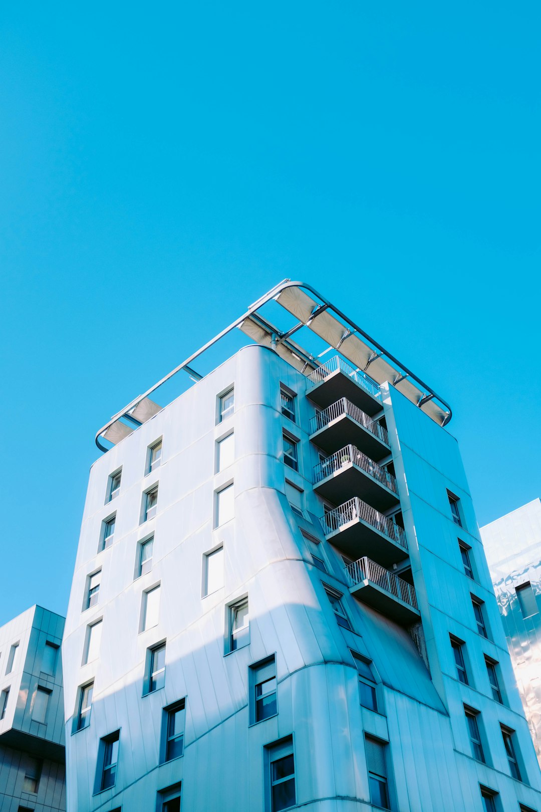 low-angle photography of a concrete building under a calm blue sky