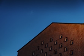 Construction workers laying bricks on a sunny building site.