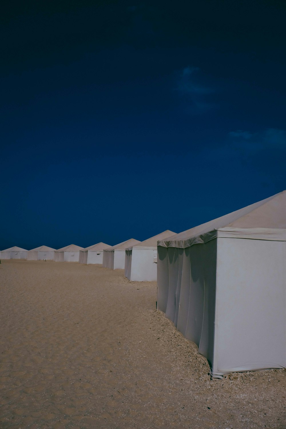 a row of tents sitting on top of a sandy beach