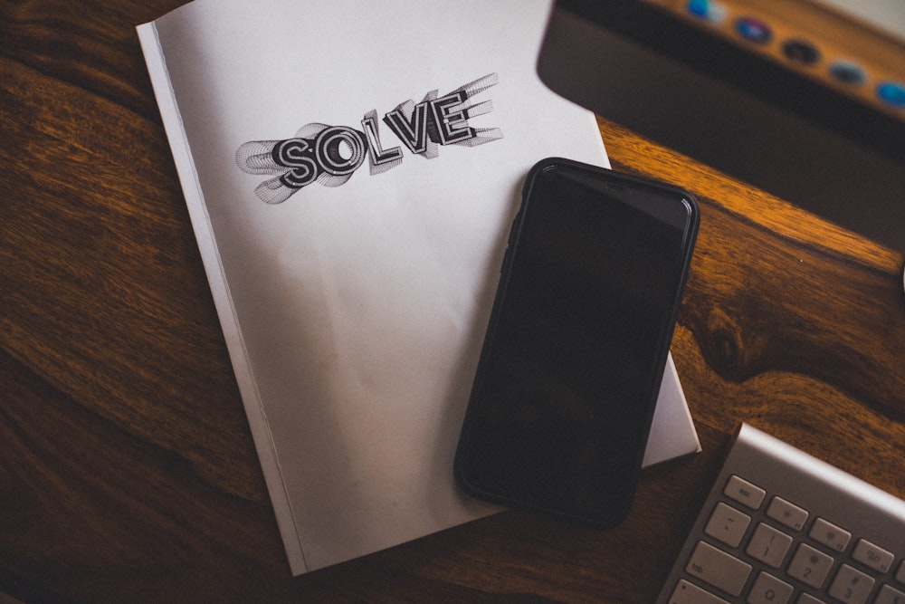 black phone on top of white notebook