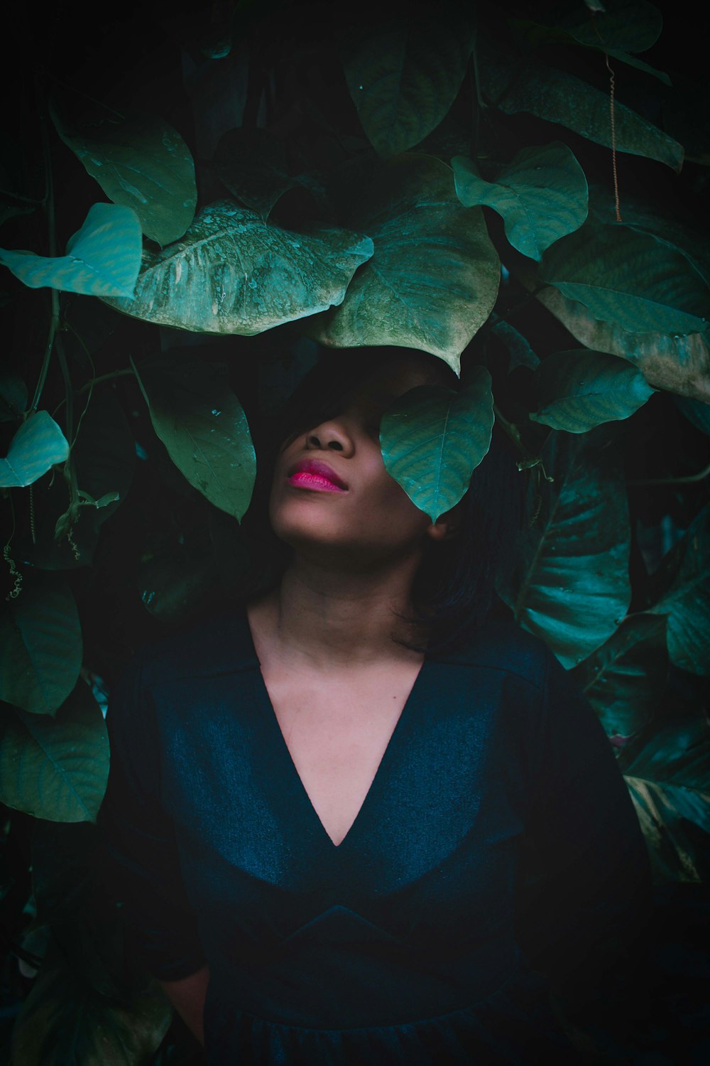 woman surrounded by green-leafed plant