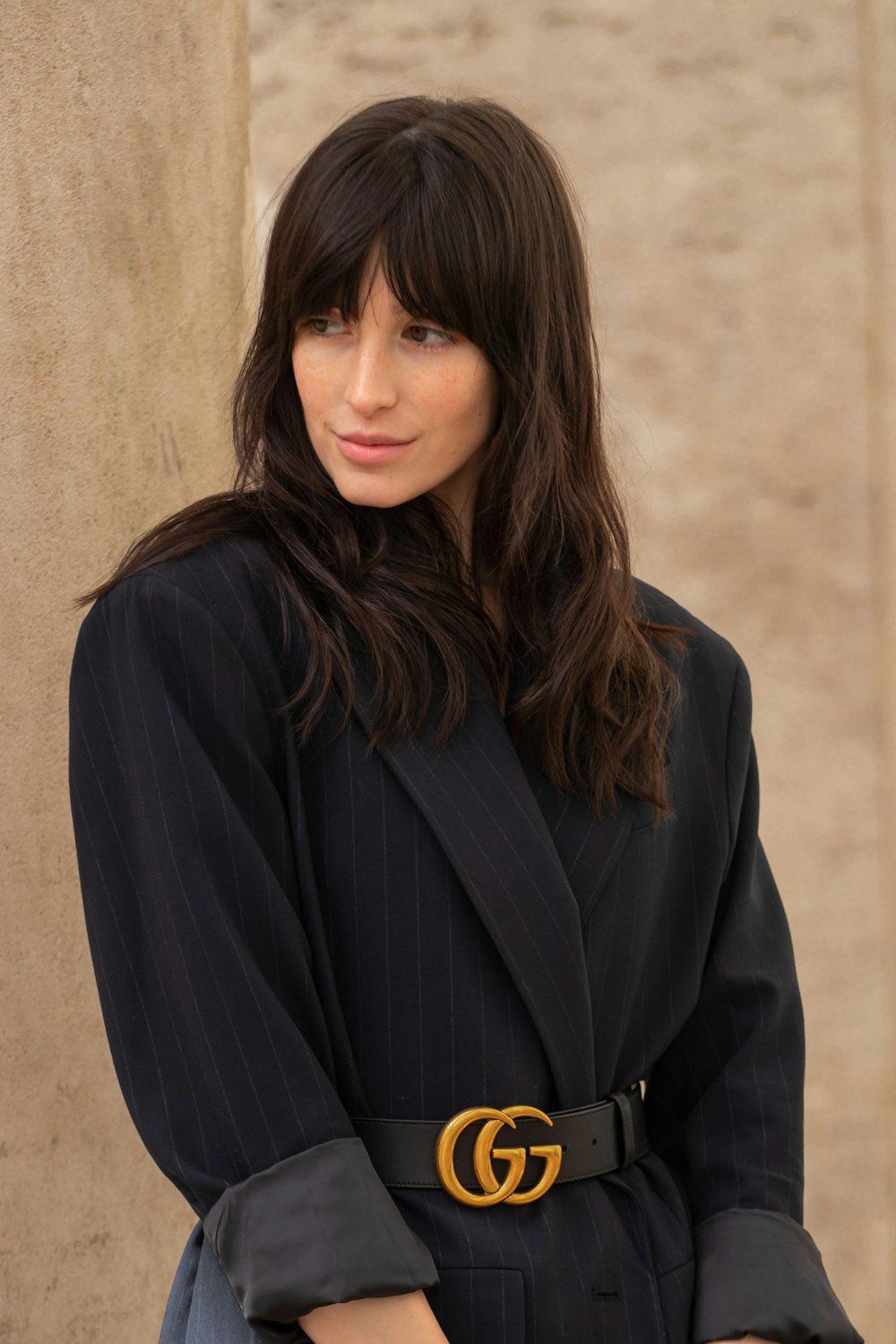 woman in black coat and black Gucci belt