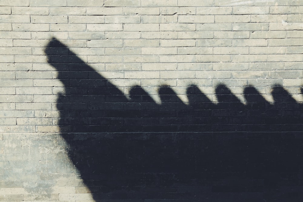 a shadow of a group of people on a brick wall