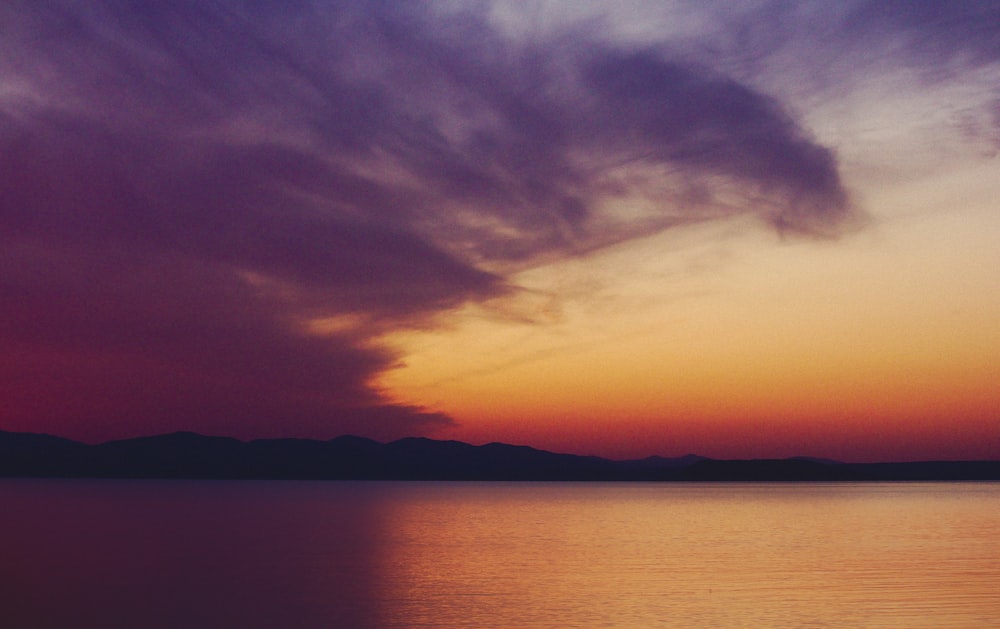 mountain by a lake at sunset