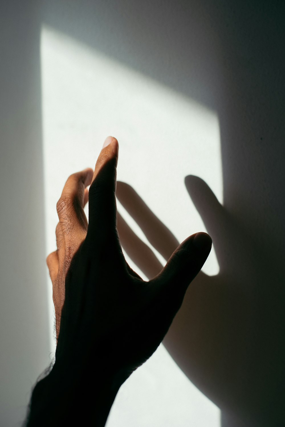 linke Hand und Schatten der Person