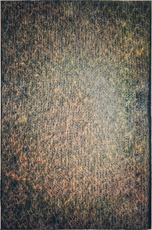 Close-up of a handcrafted tapestry showcasing intricate weaving patterns in warm earthy tones.