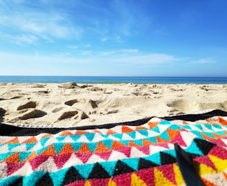 A peaceful beach setting with a yoga mat and ocean waves.