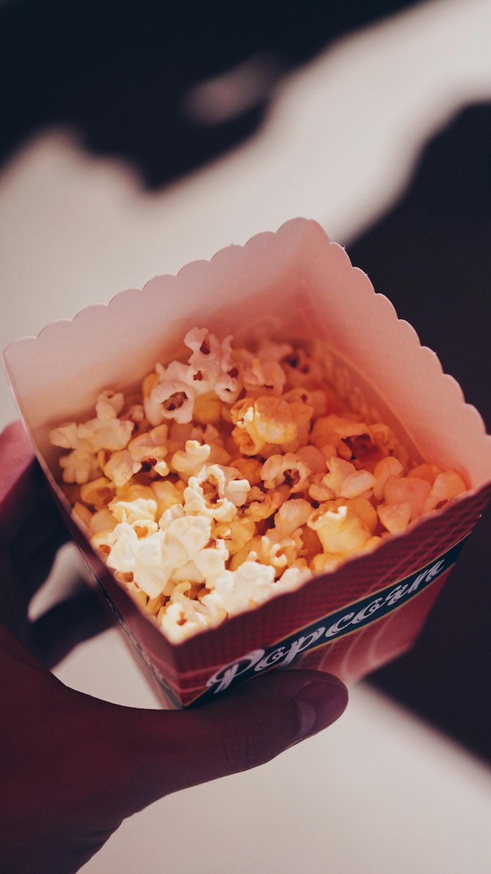 Persona sosteniendo palomitas de maíz en una caja