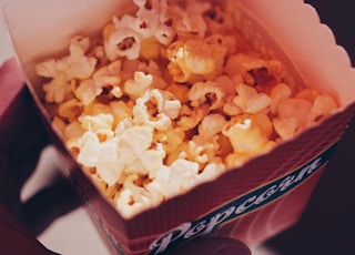 person holding popcorn in box