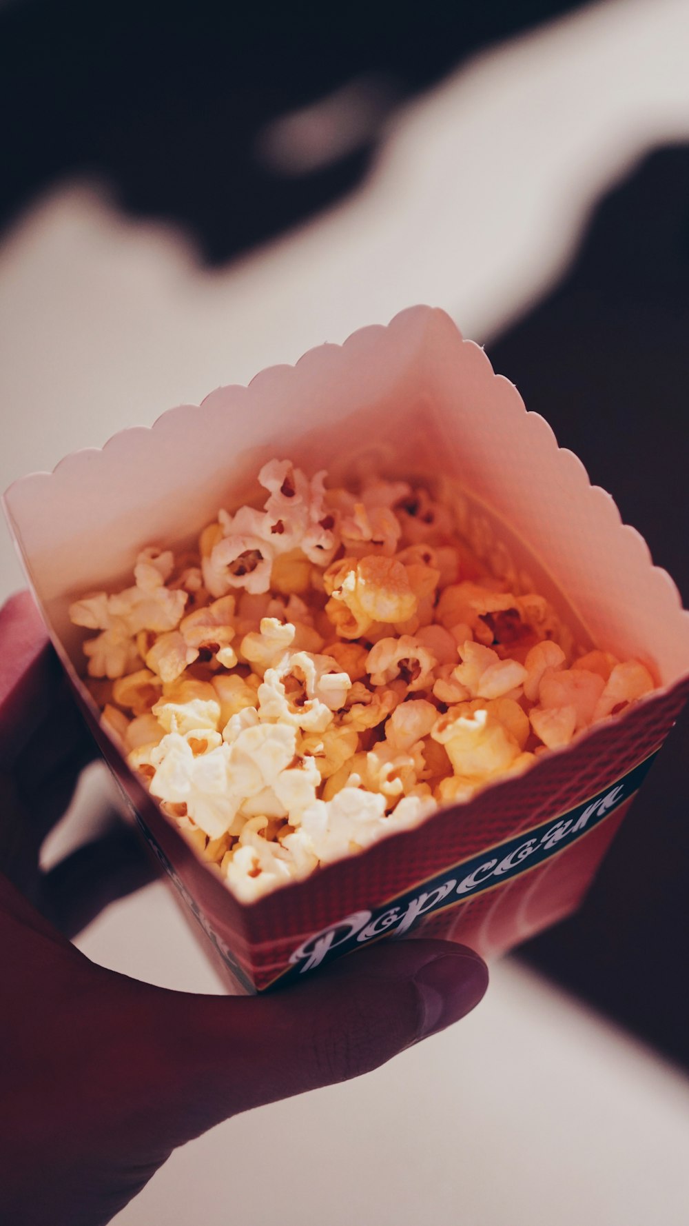 person holding popcorn in box