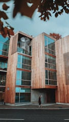 woman with her pet walks near brown building with glass windows