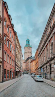 Historic European city street with colorful buildings and cobblestone pavement.