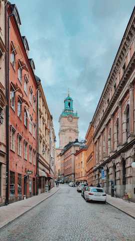Historic European city street with colorful buildings and cobblestone pavement.