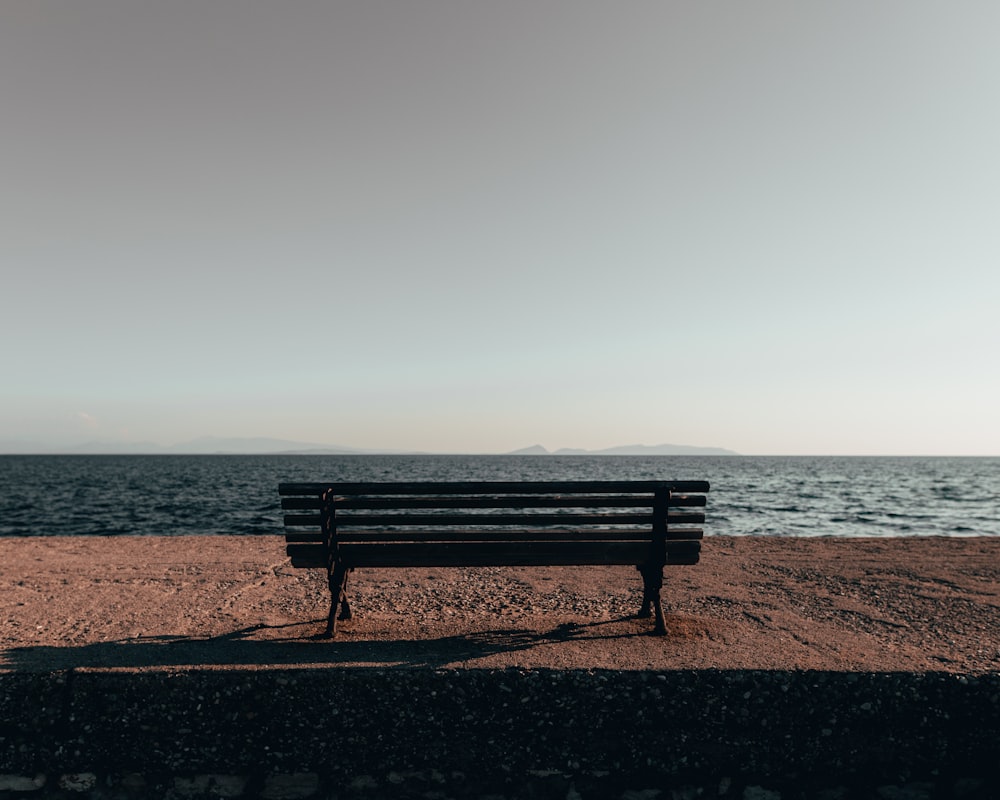 brown wooden bench at a cliff