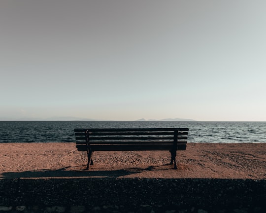 brown wooden bench at a cliff in Messolonghi Greece