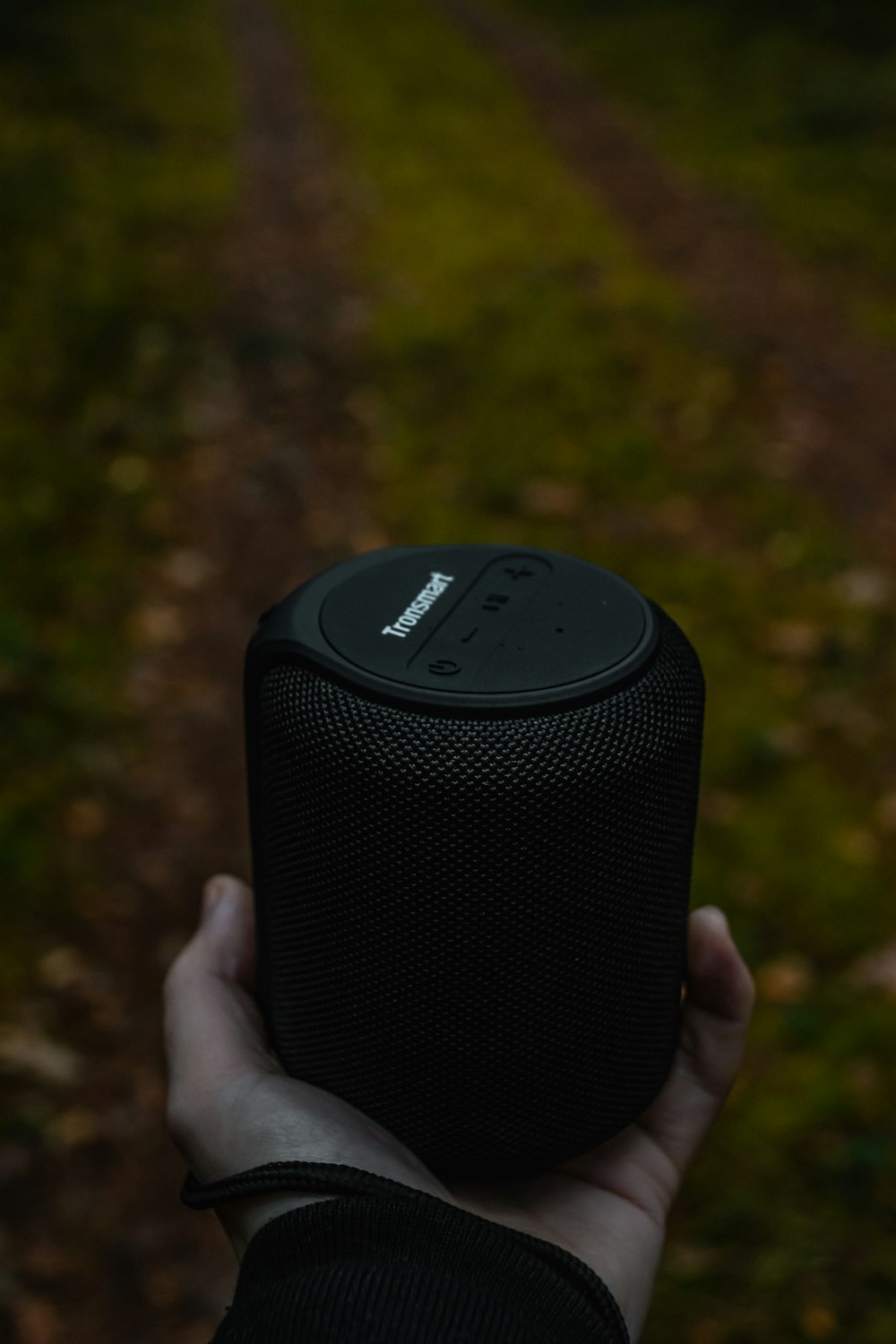 person holding black wireless speaker