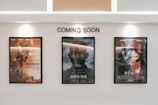 Three framed movie posters are displayed on a wall beneath the text 'COMING SOON.' The central poster features the title 'Gemini Man,' while the other two posters are in another language and contain action-themed imagery.