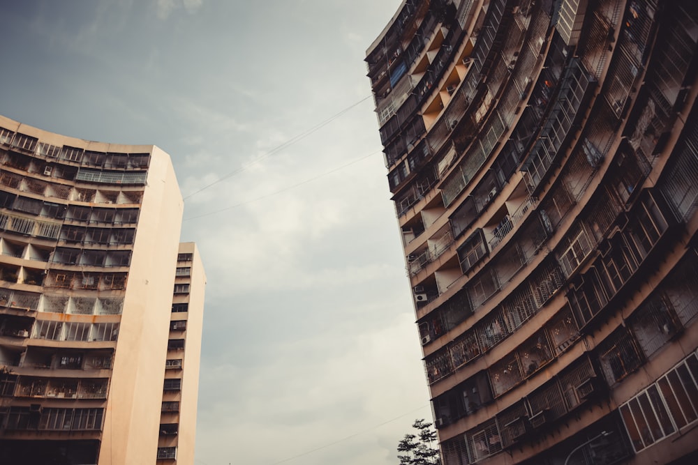 low-angle photography of brown high-rise buildings under white and blue sky during daytime