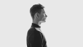 Side profile of a young man showing a clean low fade hairstyle under natural light.