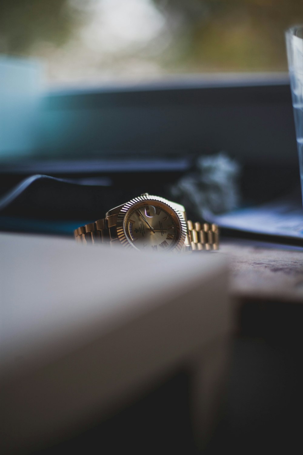 round gold-colored analog watch with link band