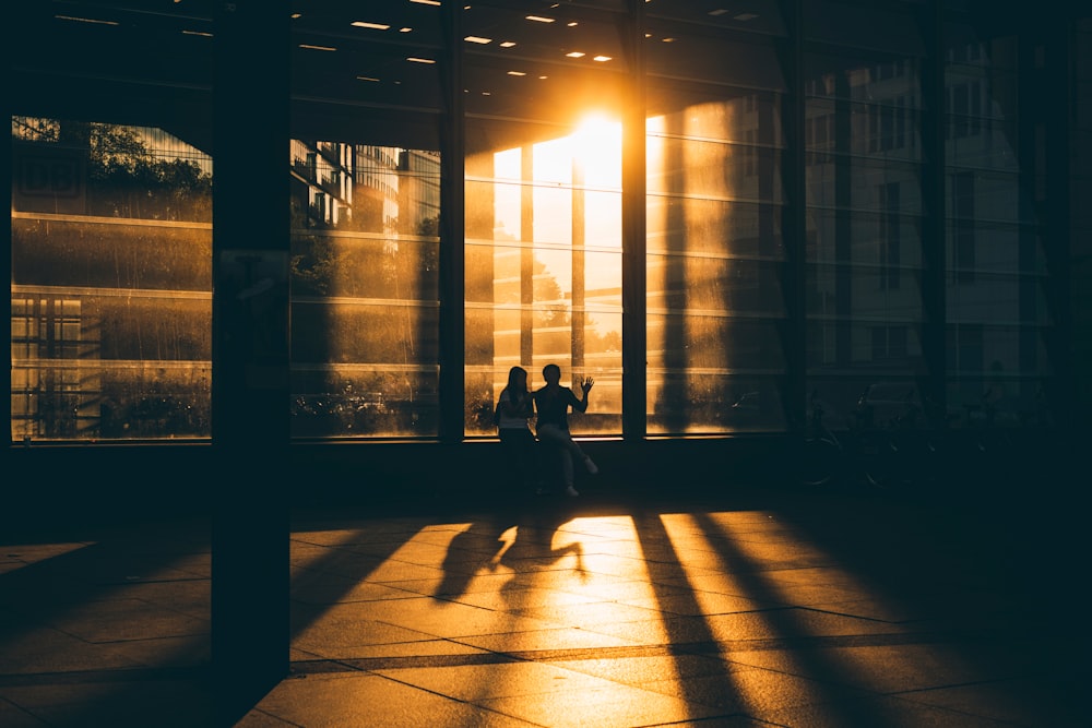 two person standing near glass building during night time