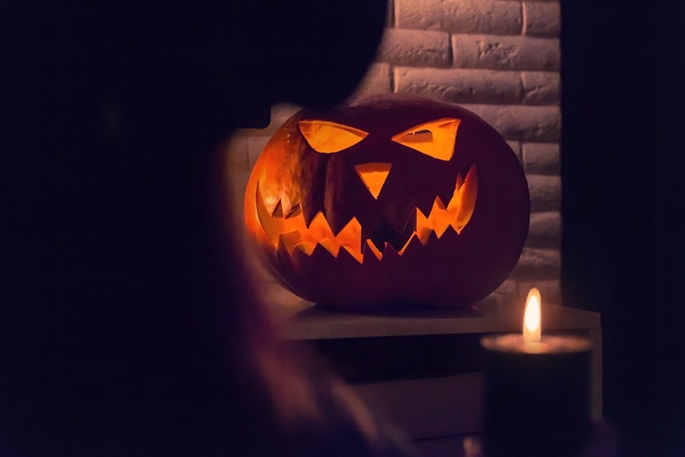 lighted pumpkin on brown wooden table