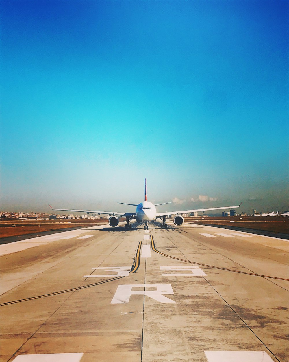 white passenger plane on roadway