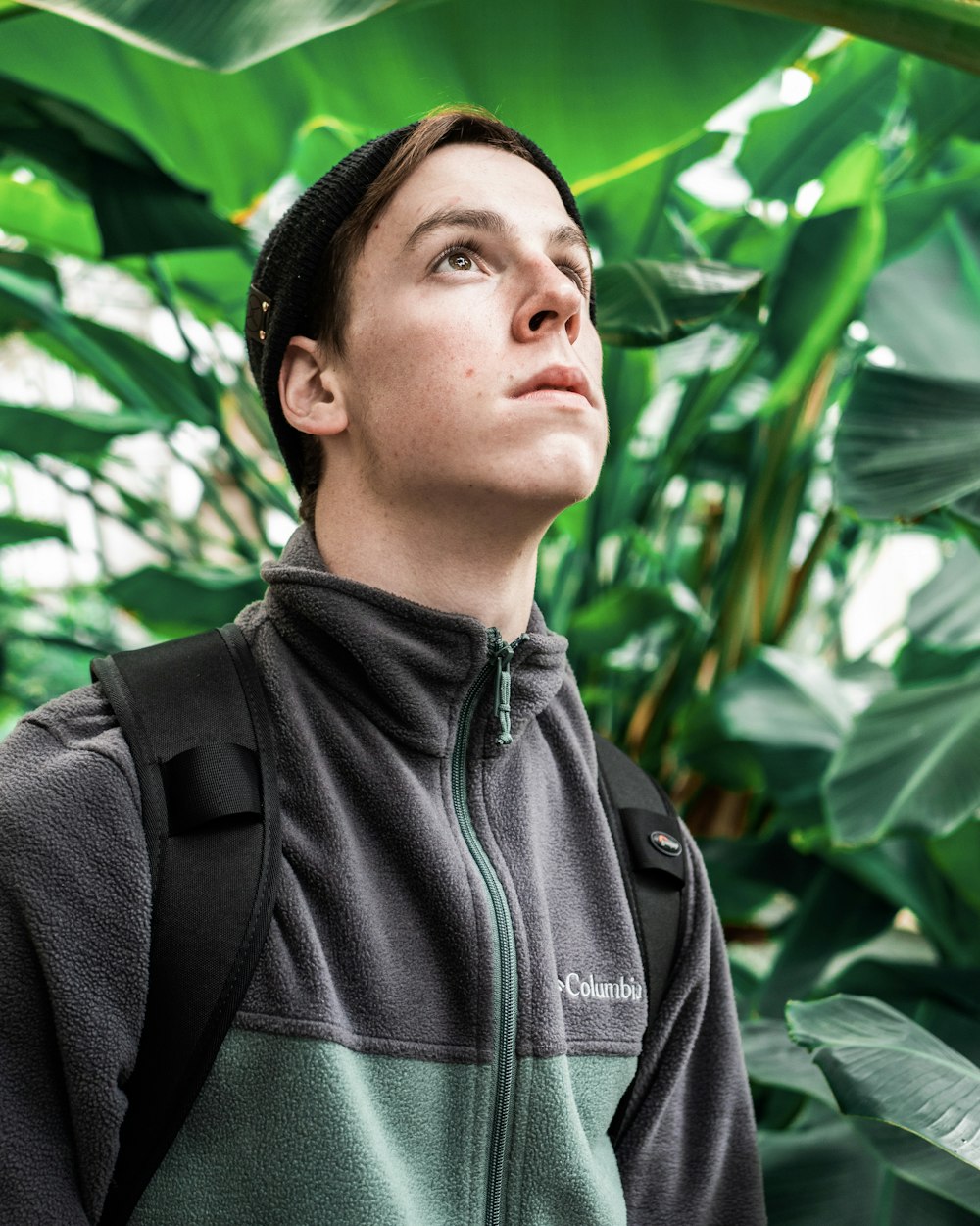 man in gray Columbia jacket beside plants