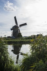 windmill beside calm body of water