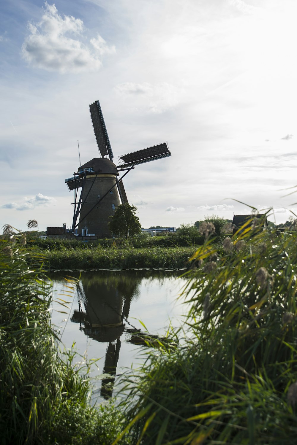 Windmühle neben ruhigem Gewässer