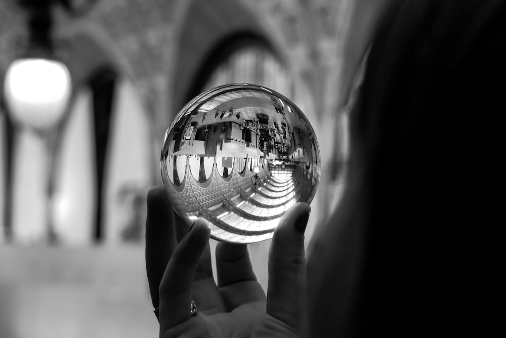 person holding glass sphre