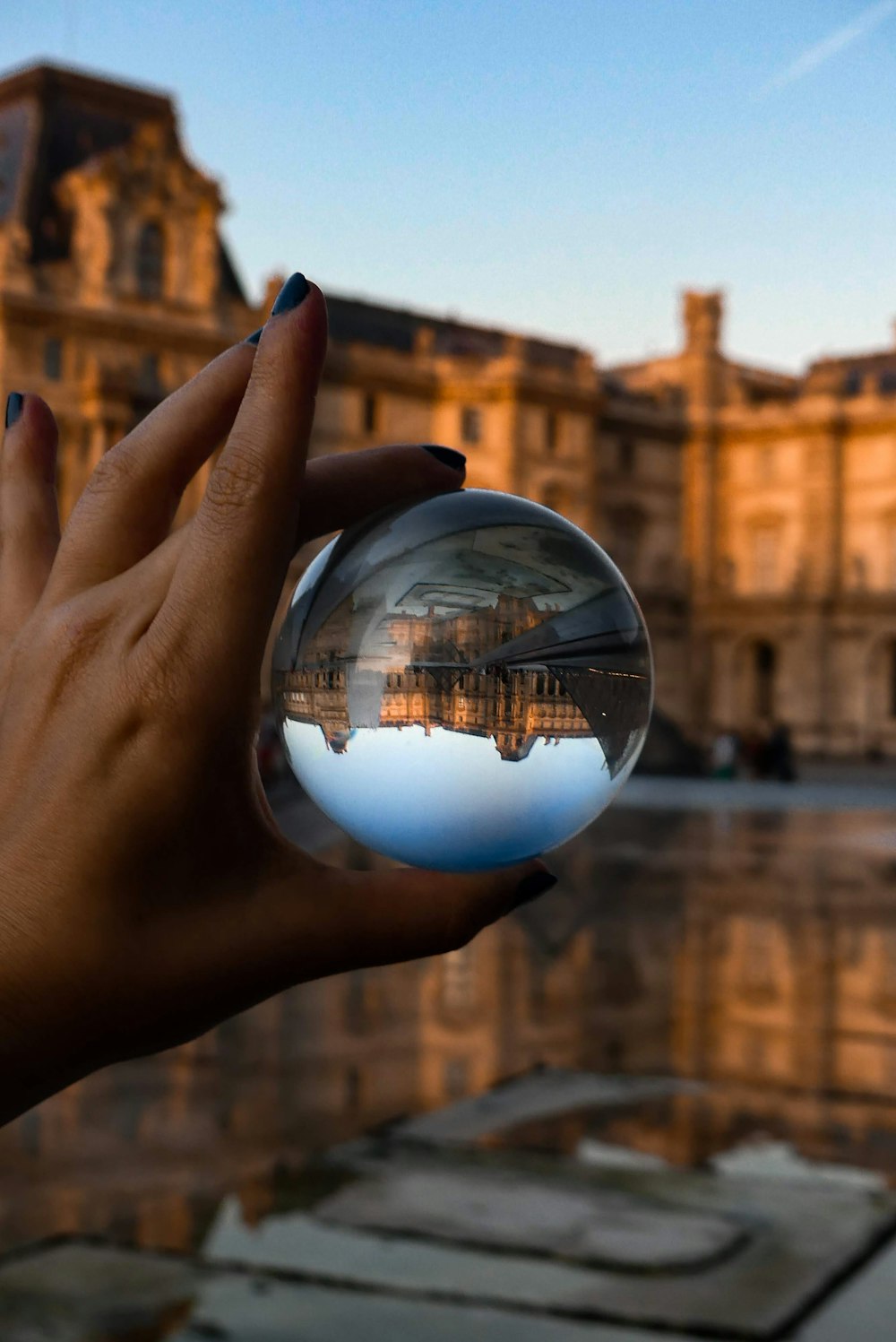 person holding glass sphere