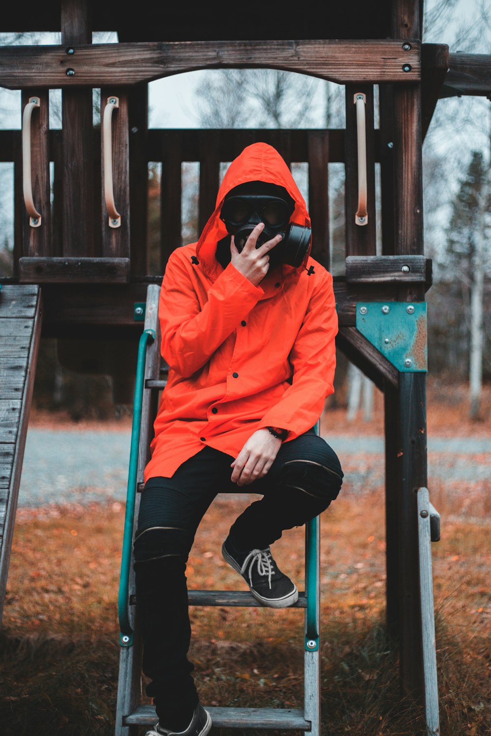 man sitting on stairs holding black gas mask