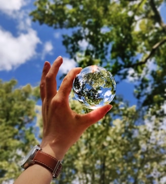 unknown person holding clear glass ball