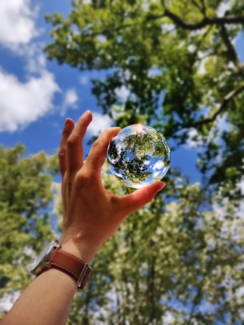 unknown person holding clear glass ball