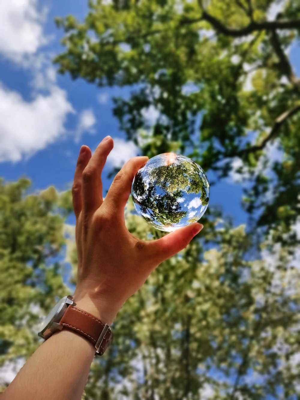 Persona desconocida sosteniendo una bola de vidrio transparente