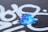 A section of black surface is covered with white spray-painted patterns, including swirling lines and abstract shapes. A portion of the surface is peeling, revealing a layer of vibrant blue paint underneath with remnants of rusted orange.
