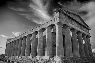 A mysterious black and white image of an ancient Greek temple, evoking a sense of history and aspiration.