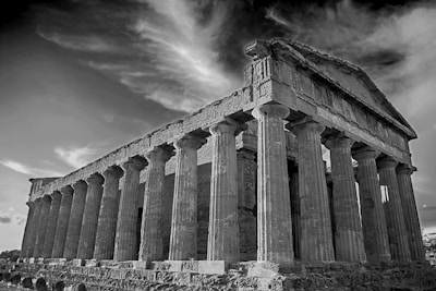A mysterious black and white image of an ancient Greek temple, evoking a sense of history and aspiration.