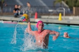 Close-up of a water polo player launching a powerful shot at the goal.