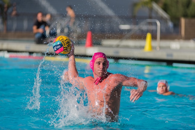 Close-up of a water polo player launching a powerful shot at the goal.