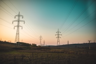 landscape photography of electric towers under a calm blue sky